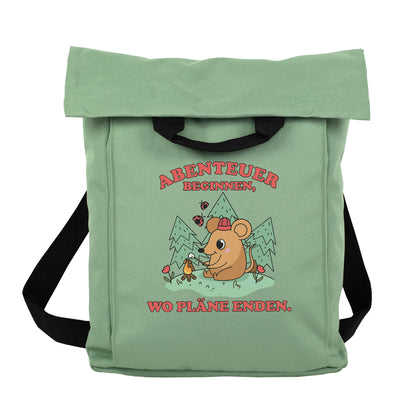 Beiger Rucksack mit Abenteuer-Maus Motiv wird beim Wandern im Wald auf dem Rücken getragen