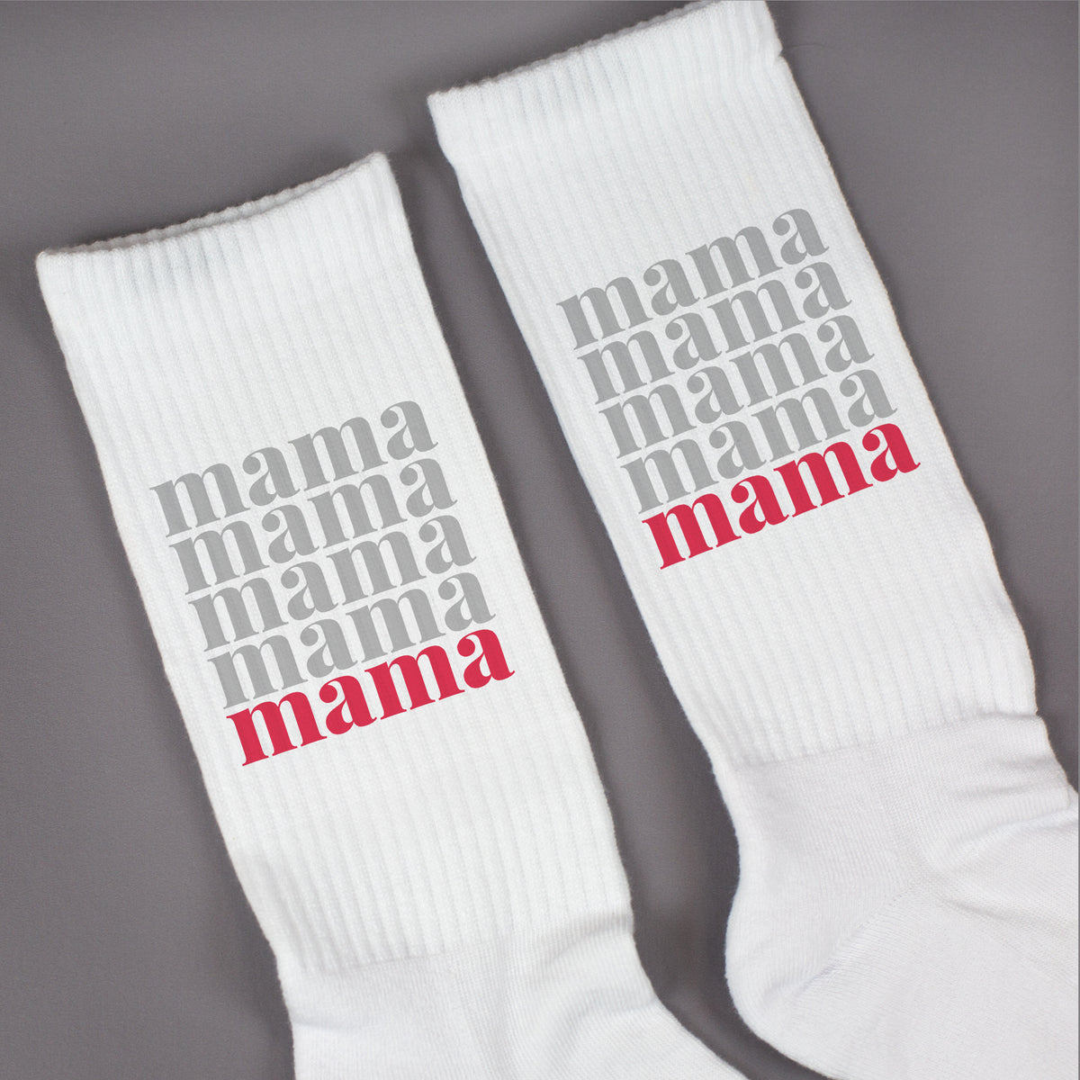 Detailaufnahme von Socken mit mehrfach „mama“ Schriftzug in Grau und rotem Highlight
