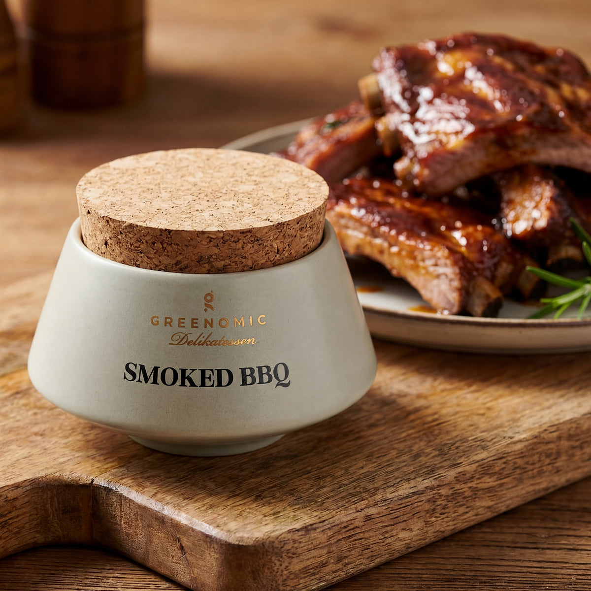 Smoked BBQ Gewürz neben saftigen BBQ-Rippchen auf Holzbrett angerichtet