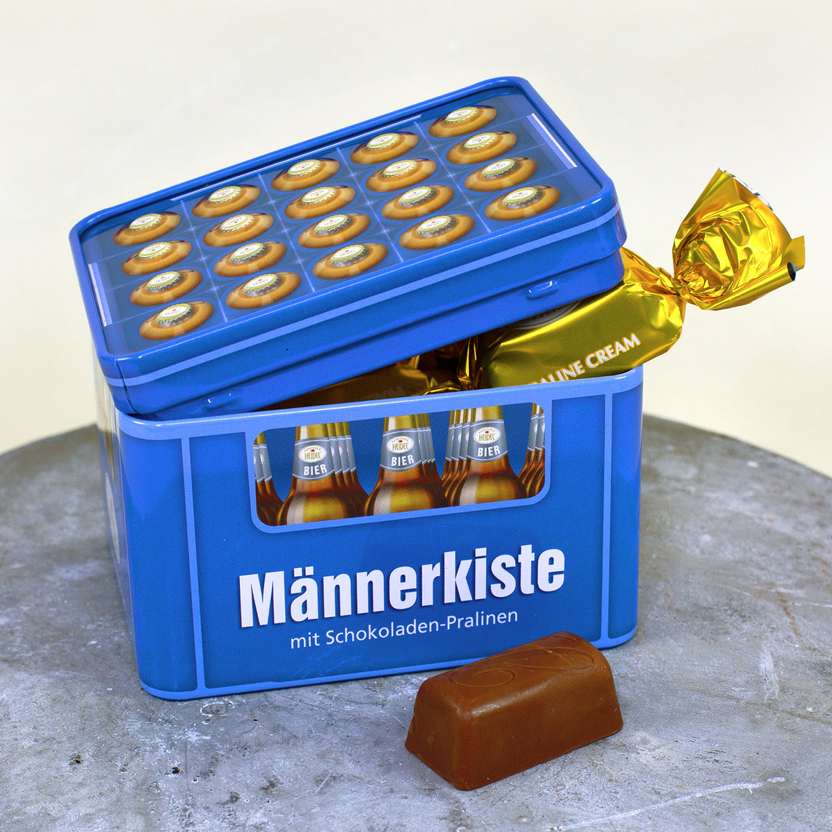 Geöffnete Männerkiste aus Metall mit einzeln verpackten Pralinencreme Schokoladen