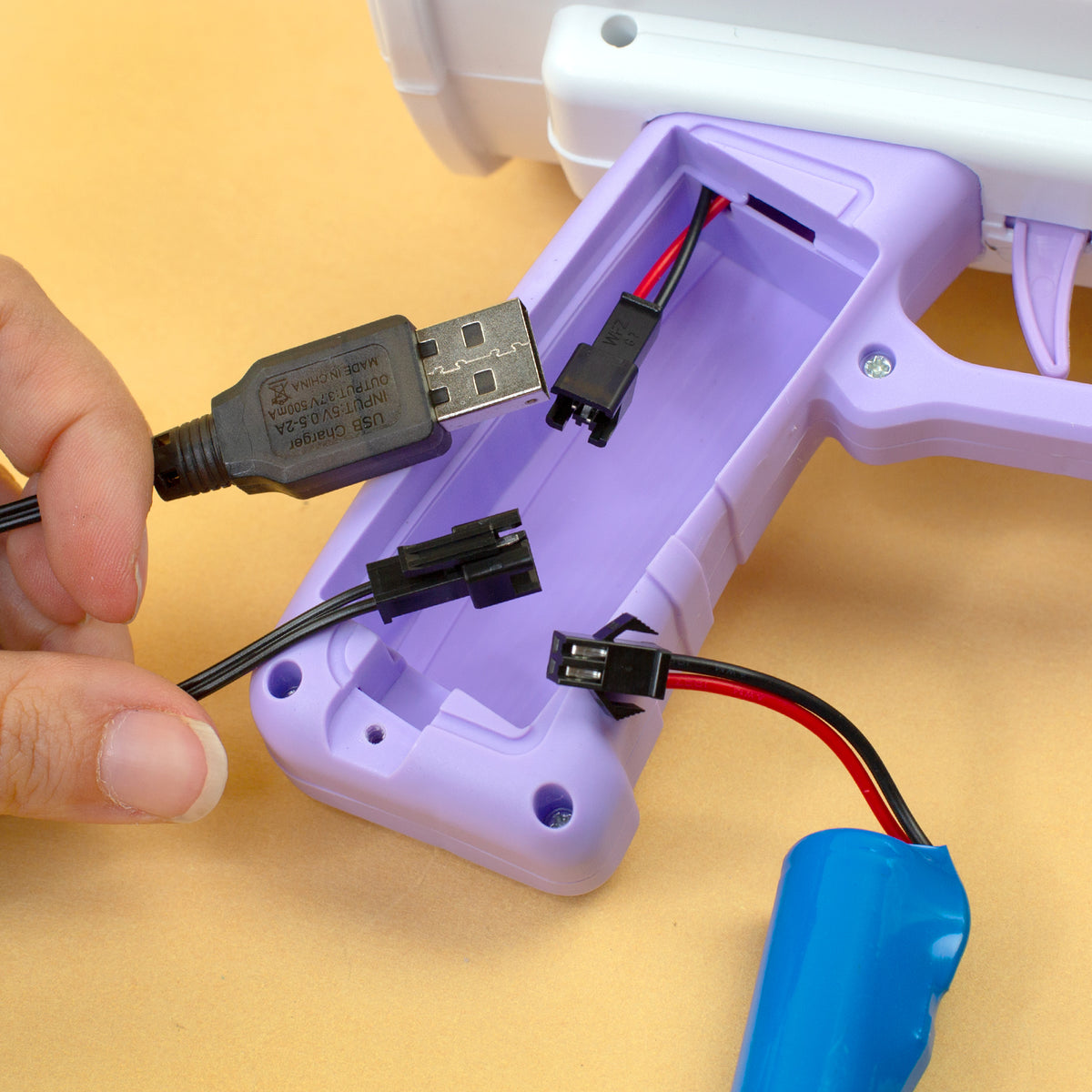 USB-Ladekabel und Anschlüsse der Seifenblasenmaschine im geöffneten Batteriefach