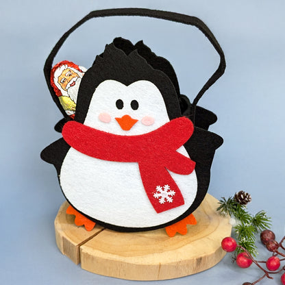Weihnachts-Geschenktasche aus Filz Motiv Pinguin mit Schal auf Baumscheibe