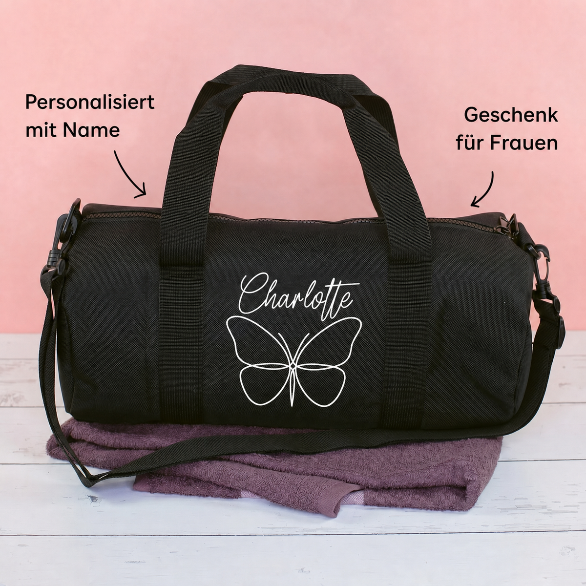 Schwarze Sporttasche mit Schmetterlingsmotiv und Name Charlotte auf rosa Hintergrund mit Produktinformationen