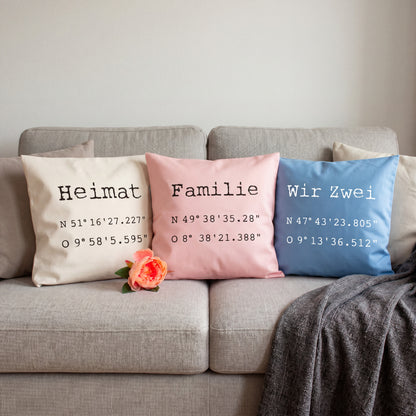 Personalisierte Koordinaten Kissen in Natur, Rosa und Blau mit Wunschtext auf Sofa