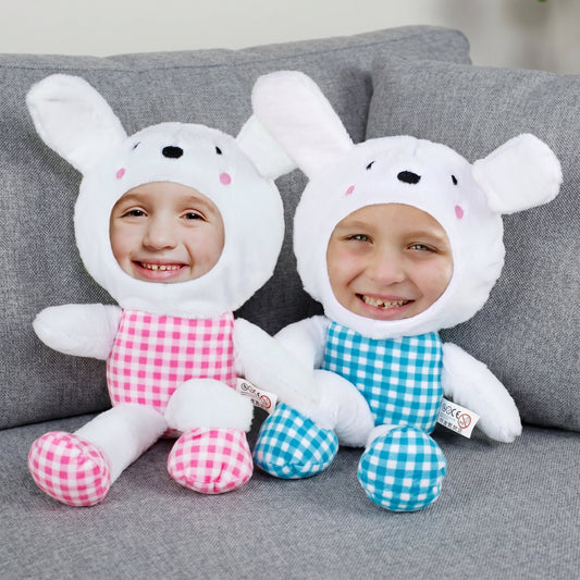 Zwei personalisierte Fotohasen in Rosa und Blau mit eigenem Gesicht auf Sofa