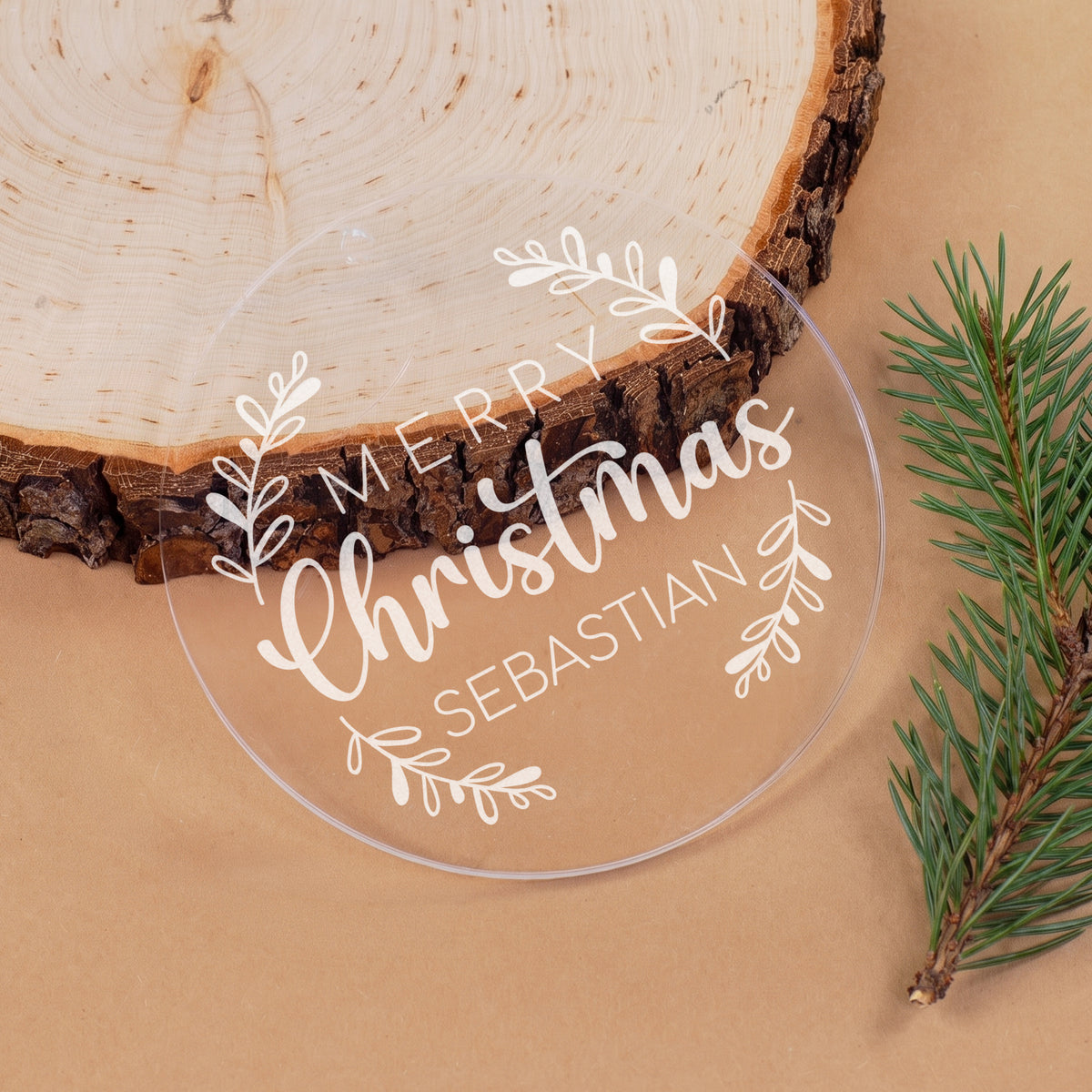 Transparente Weihnachtskugel aus Acryl mit Name Sebastian, „Merry Christmas“ Schriftzug und Zweigen auf natürlicher Dekoration