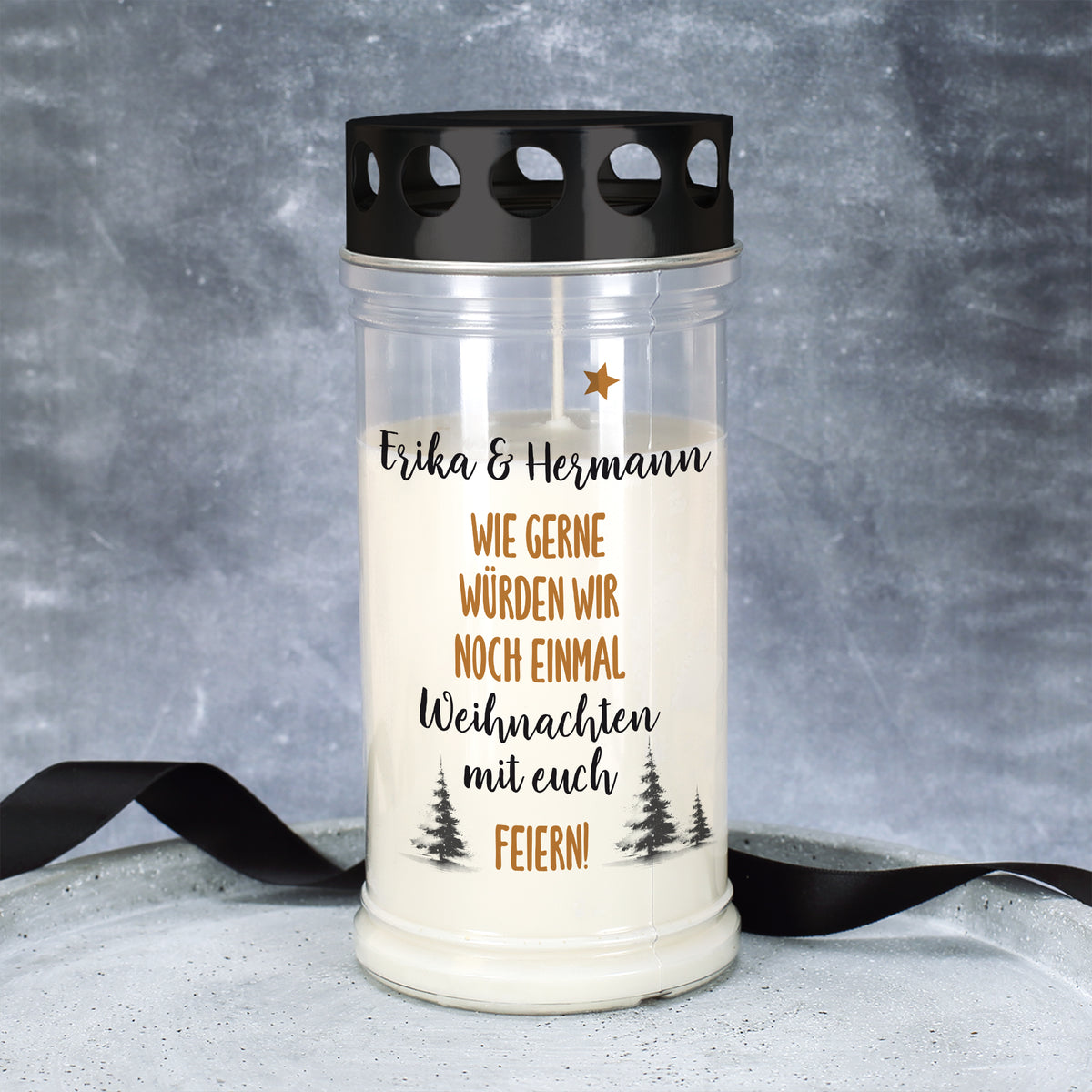 Großes Grablicht Weihnachten personalisiert mit „Erika & Hermann“, dekoriert vor grauem Hintergrund