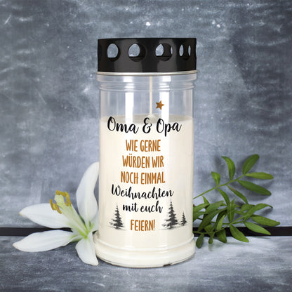 Weihnachts-Grablicht mit Aufdruck „Oma & Opa – Wie gerne würden wir noch einmal Weihnachten mit euch feiern!“ neben weißer Lilie
