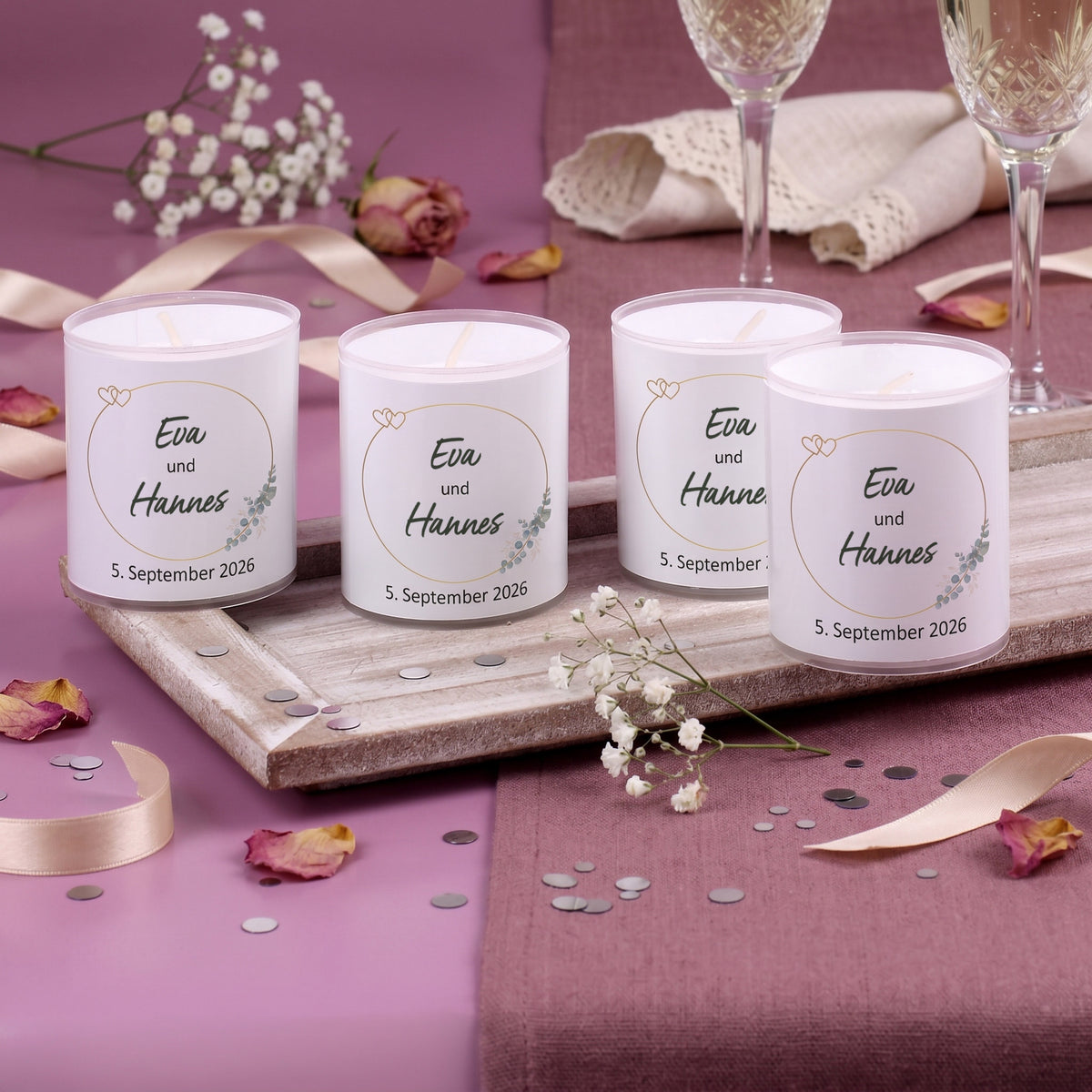 Hochzeitskerzen im 4er Set mit Namen Eva und Hannes auf rosa dekoriertem Tisch
