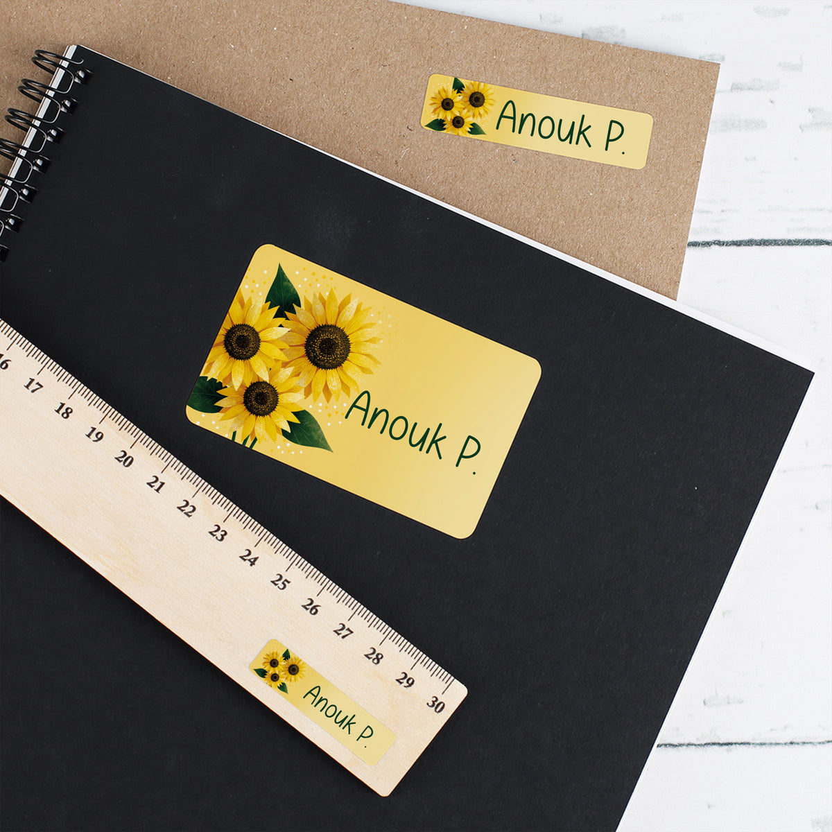Namensaufkleber mit Sonnenblumen und Name Anouk P. auf Heft, Umschlag und Lineal
