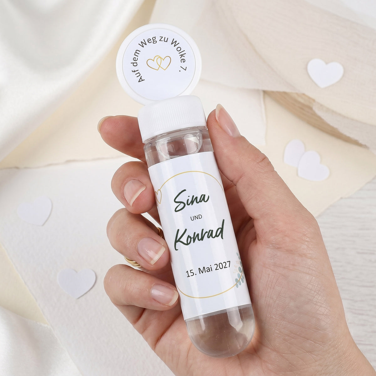 Personalisierte Seifenblasen zur Hochzeit mit Namen Sina und Konrad in einer Hand gehalten