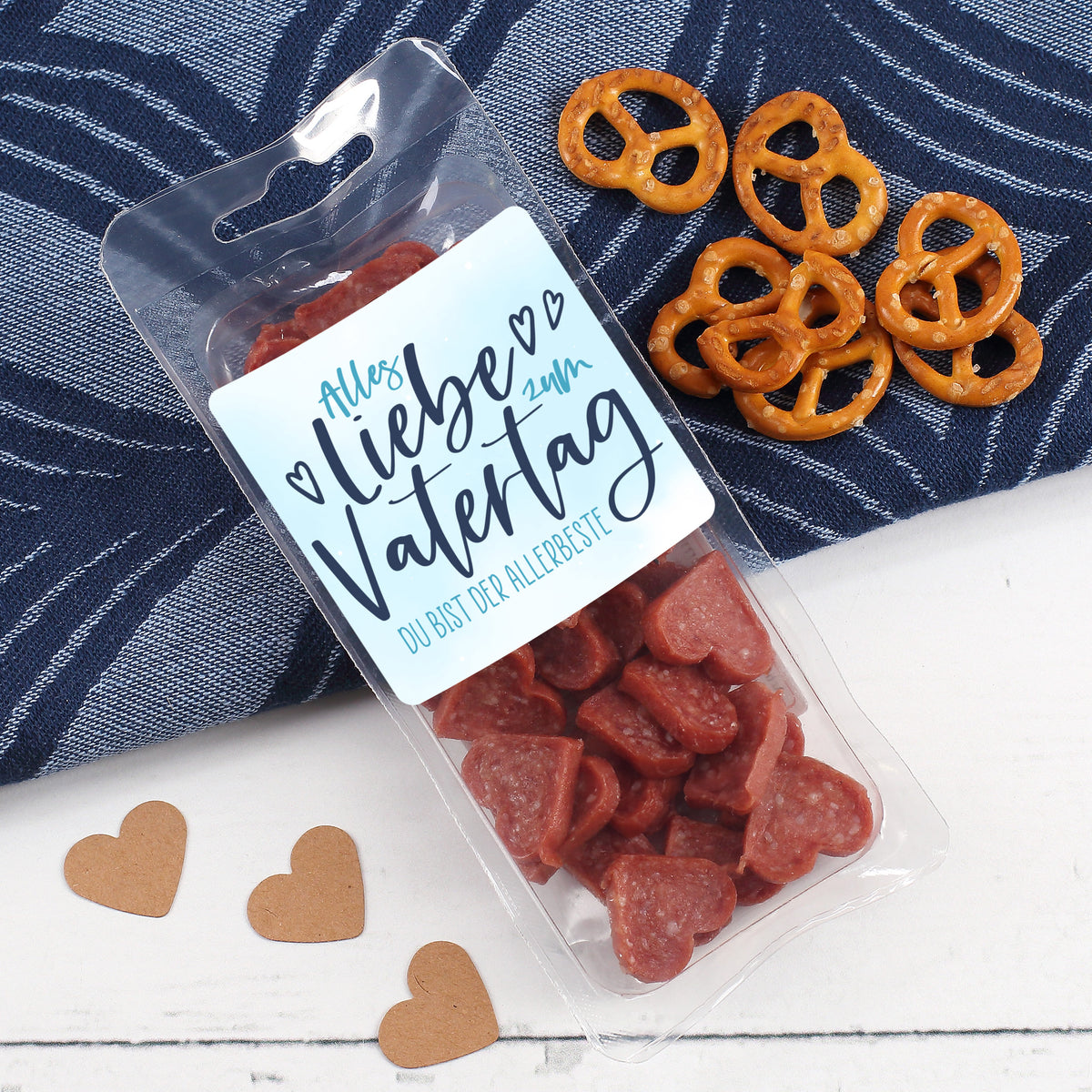 Salami Herzen in Verpackung mit Vatertagsdesign neben Snacks und Dekoration