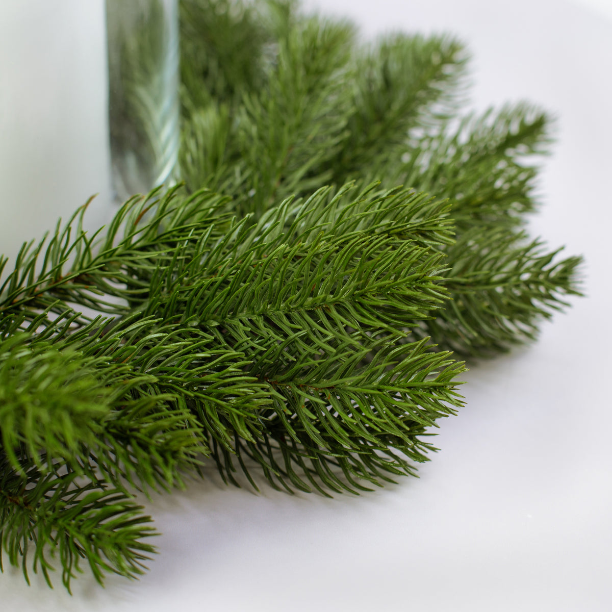 Detailaufnahme künstlicher Tannenzweige des Weihnachtskranzes