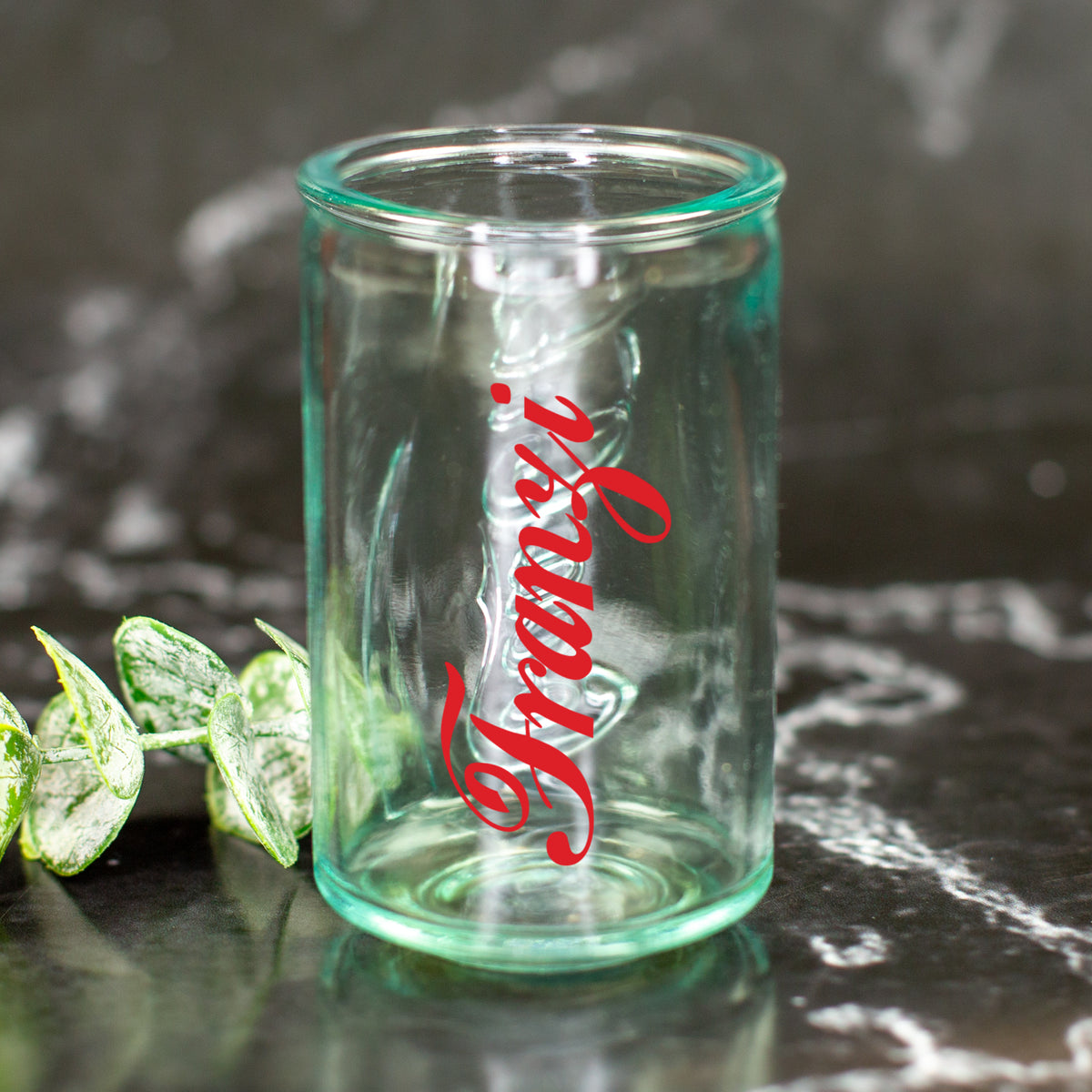 Personalisiertes Mini Shotglas mit rotem Namen Franzi im Coca-Cola Retro-Stil auf dunkler Oberfläche