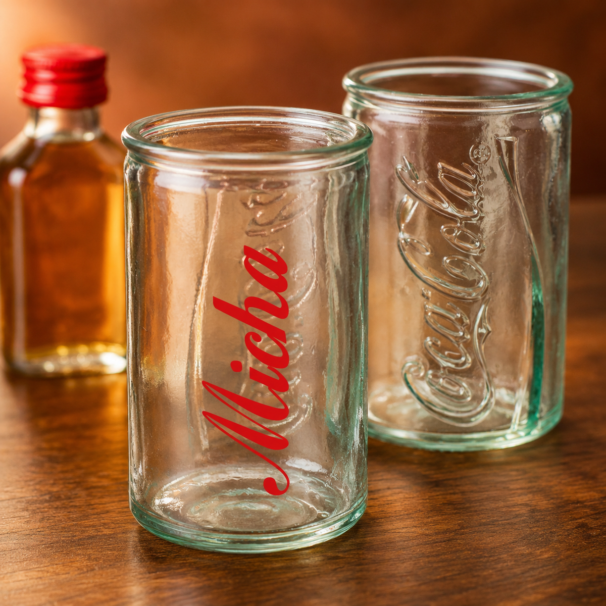 Gefülltes Coca-Cola Shotglas mit Name Micha, hellem Schnaps und durchscheinendem Reliefschriftzug