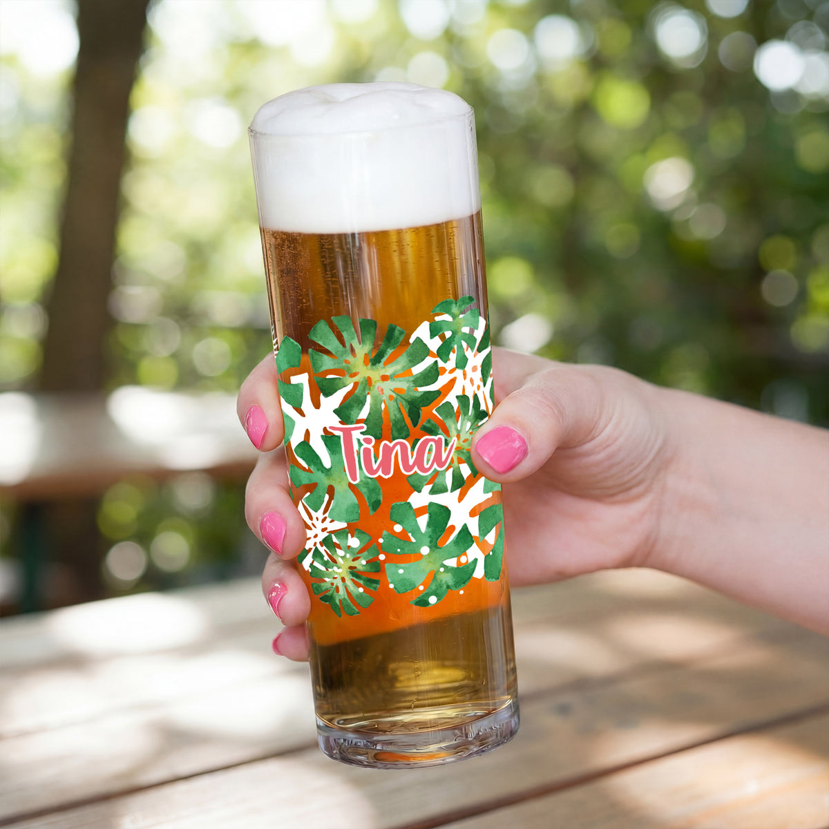 Kölschstange mit tropischem Monstera-Blätter-Motiv und Name Tina in der Hand