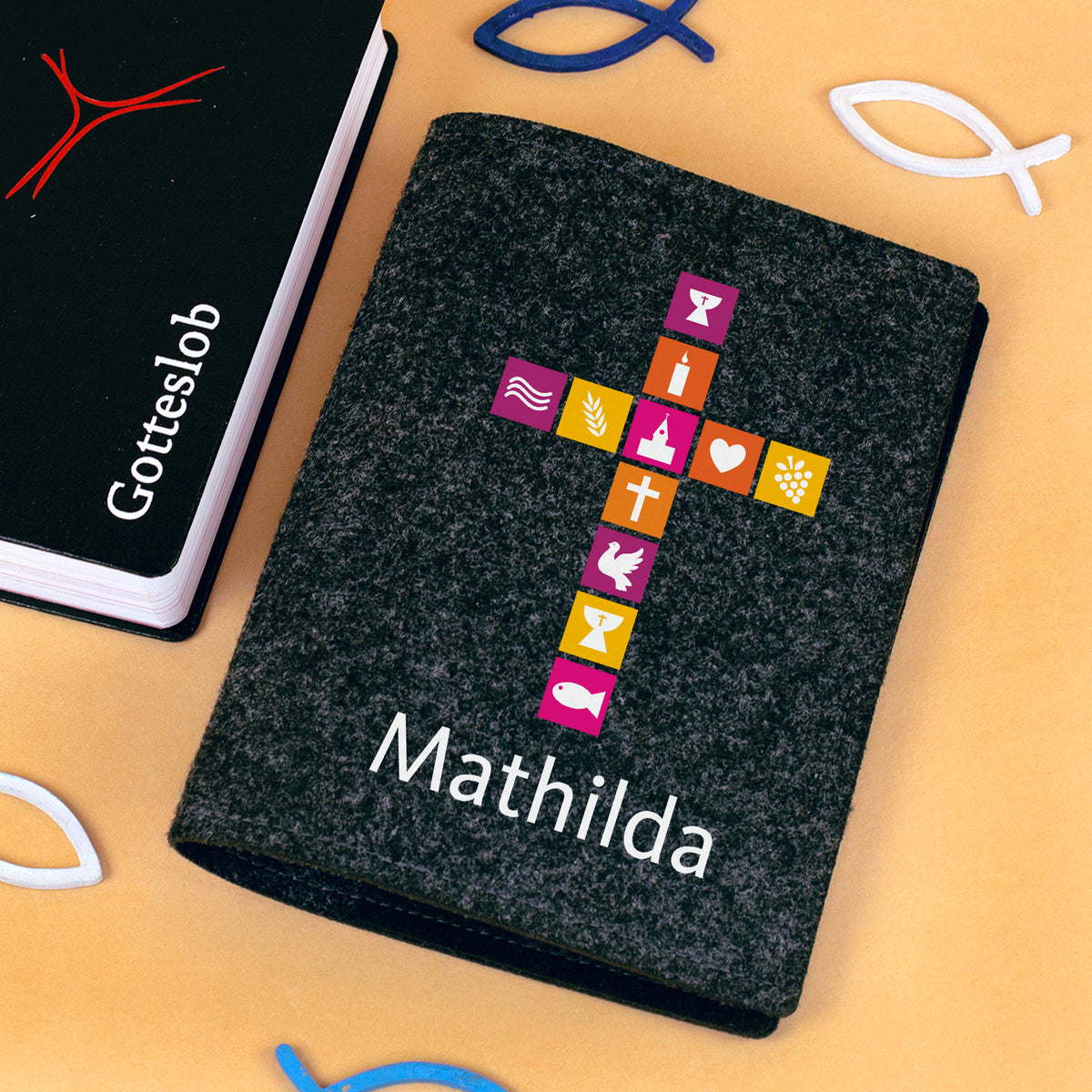 Orange Buchhülle aus Filz mit Kreuz-Motiv, christlichen Symbolen und Name als Hülle für Gotteslob