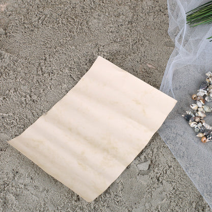 Flaschenpost Geschenkidee mit Glasflasche, Brief und maritimer Dekoration auf Sand