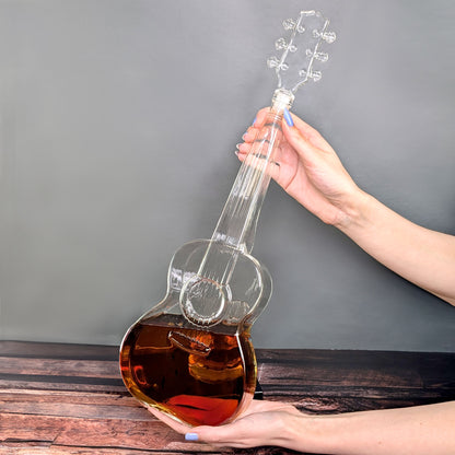Karaffe in Gitarrenform gehalten von zwei Händen