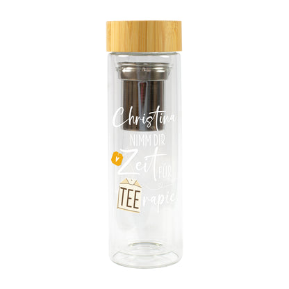 Freigestellte personalisierte Glasflasche mit Teesieb, Bambusdeckel, Wunschname Christina und Spruch „Nimm dir Zeit für TEErapie“ auf weißem Hintergrund