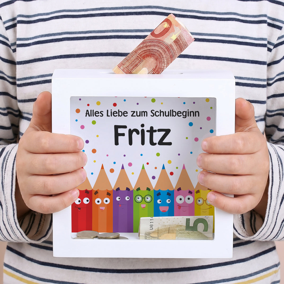 Bilderrahmen-Spardose mit Name Fritz und Text Alles Liebe zum Schulbeginn in Kinderhänden