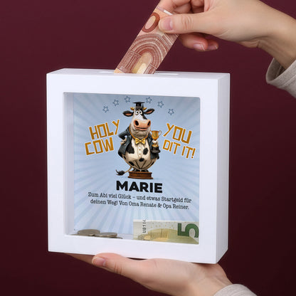 Hand steckt Geldschein in personalisierte Bilderrahmen-Spardose mit Name Marie zum bestandenen Abitur