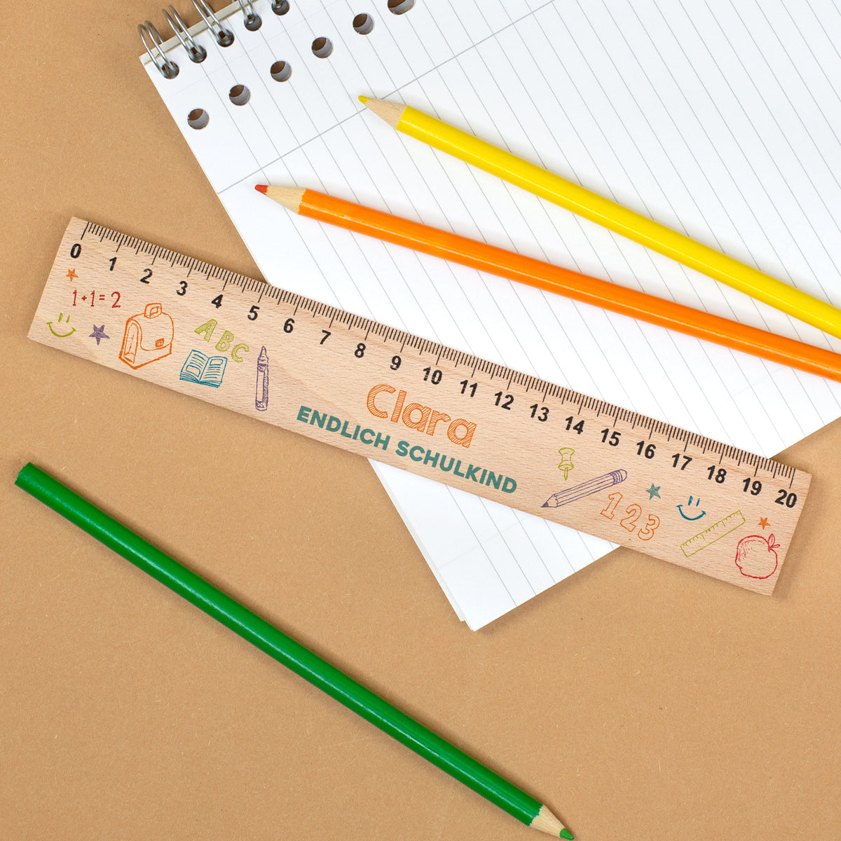 Personalisiertes Lineal aus Holz mit Name Clara und Text „Endlich Schulkind“ auf Notizblock mit Stiften