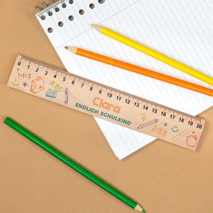 Personalisiertes Lineal aus Holz mit Name Clara und Text „Endlich Schulkind“ auf Notizblock mit Stiften