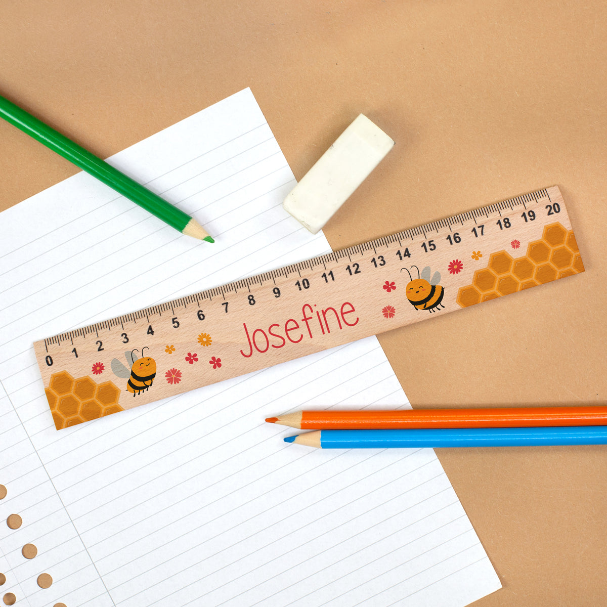 Personalisiertes Bienen-Lineal aus Holz mit Name Josefine auf Schulheft mit Stiften und Radiergummi