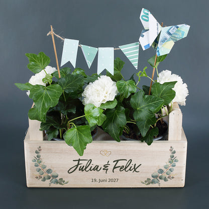 Pflanzkorb zur Hochzeit mit Efeu, weißen Blumen, Wimpelkette und Geldschein-Schmetterling