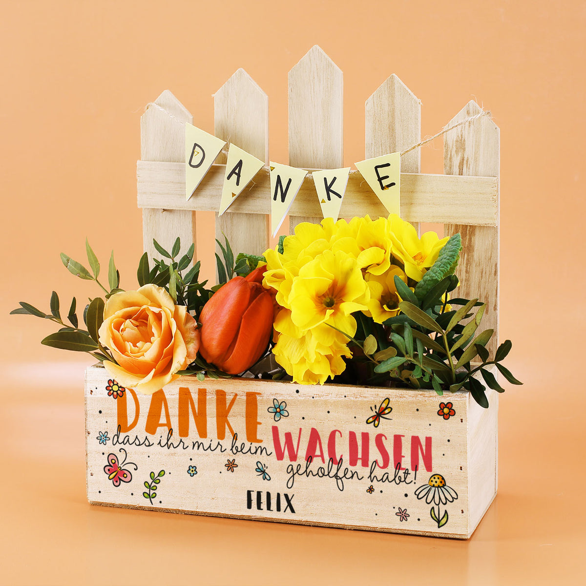 Pflanzkorb mit Blumen und Zaun, Aufdruck „Danke, dass ihr mir beim Wachsen geholfen habt“ und Name „Felix“