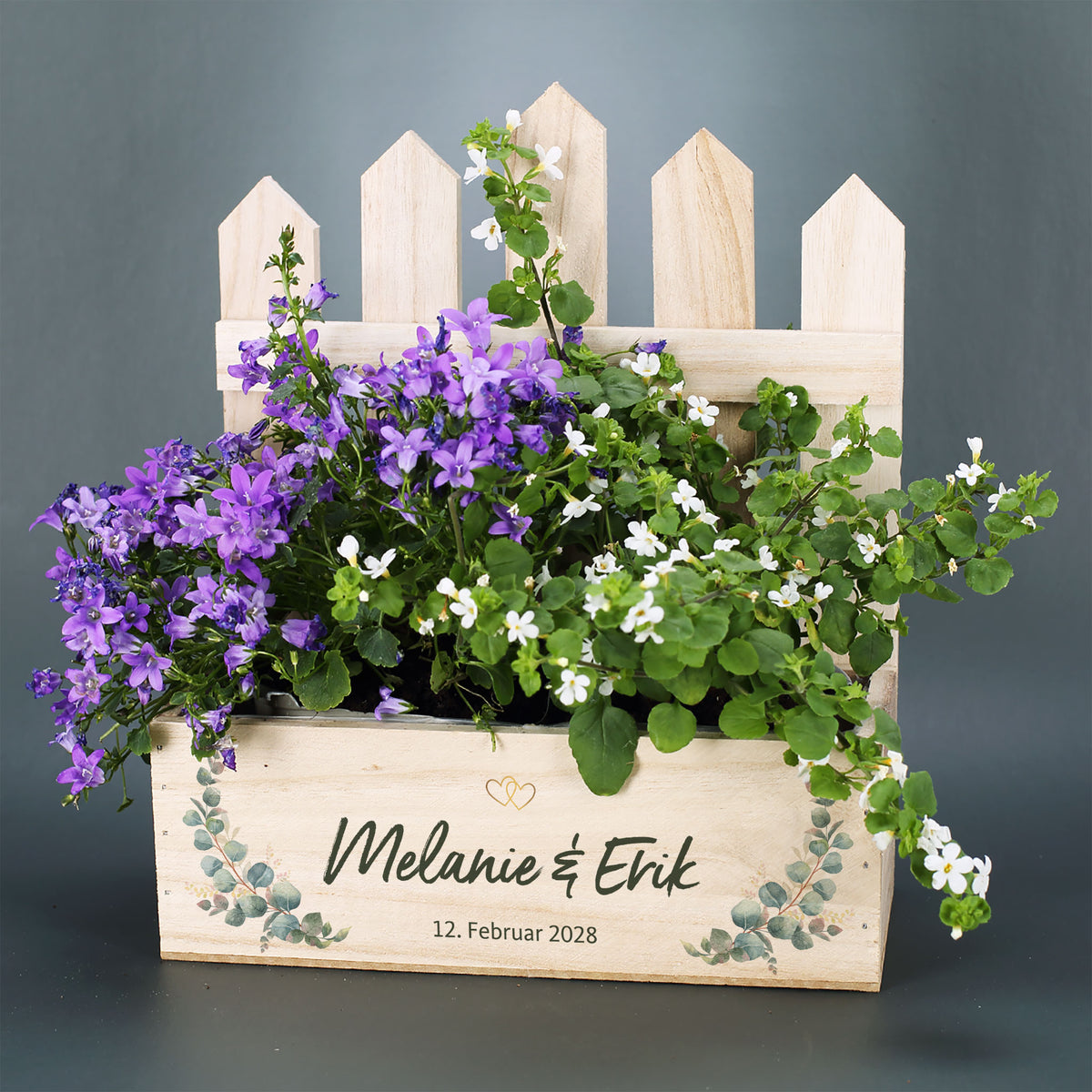 Pflanzkorb zur Hochzeit mit Zaun, violetten und weißen Blumen, Namen Melanie und Erik sowie Datum