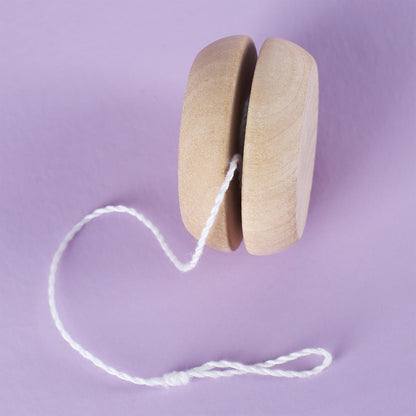 Seitenansicht eines natürlichen Holz-Yo-Yos mit aufgewickelter weißer Schnur