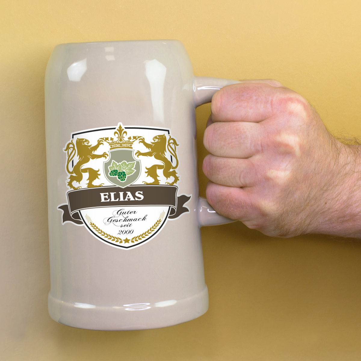 Bierkrug mit Name Elias und Jahr 2000 wird am Henkel gehalten