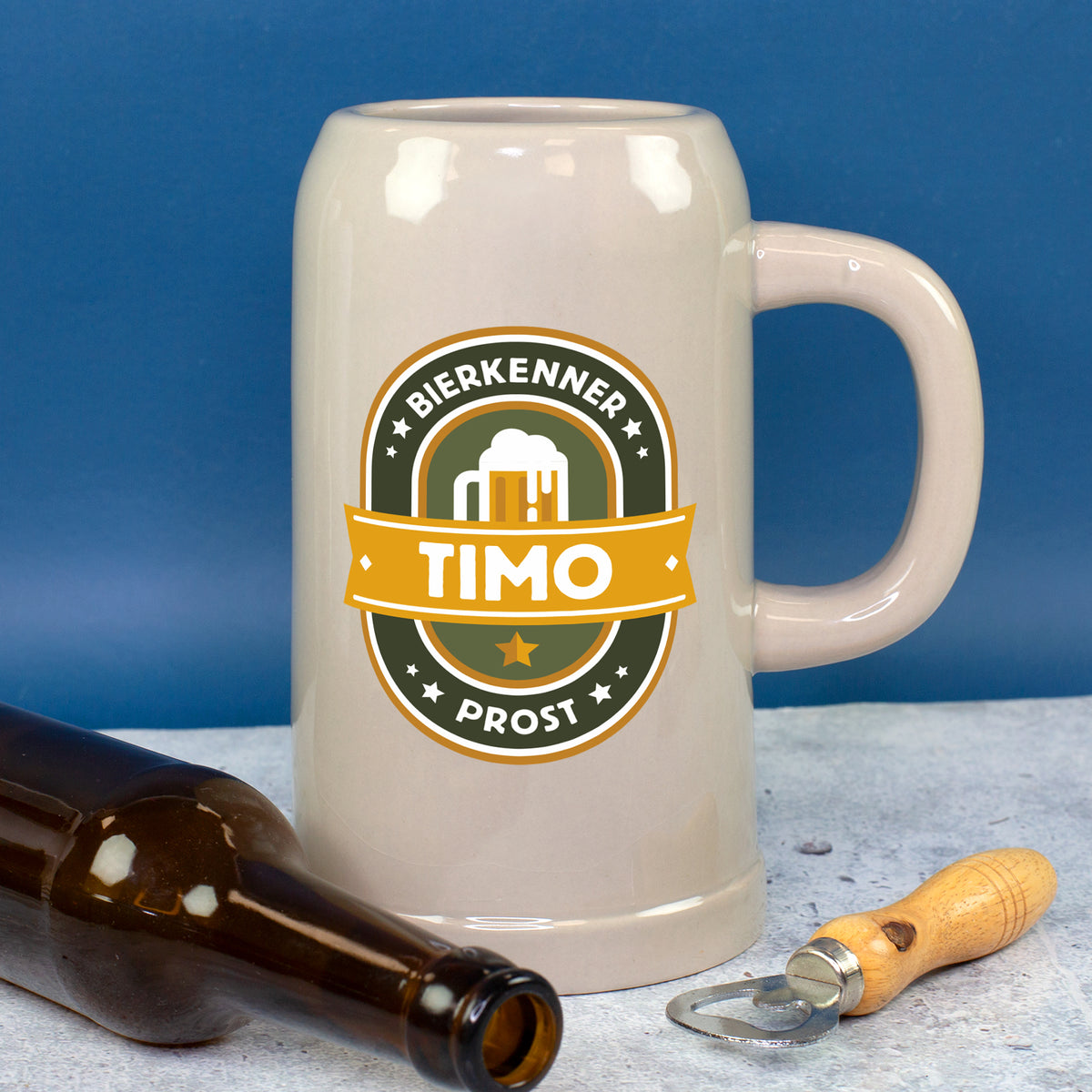 Personalisierter Bierkrug aus Keramik neben Flaschenöffner und Bierflasche