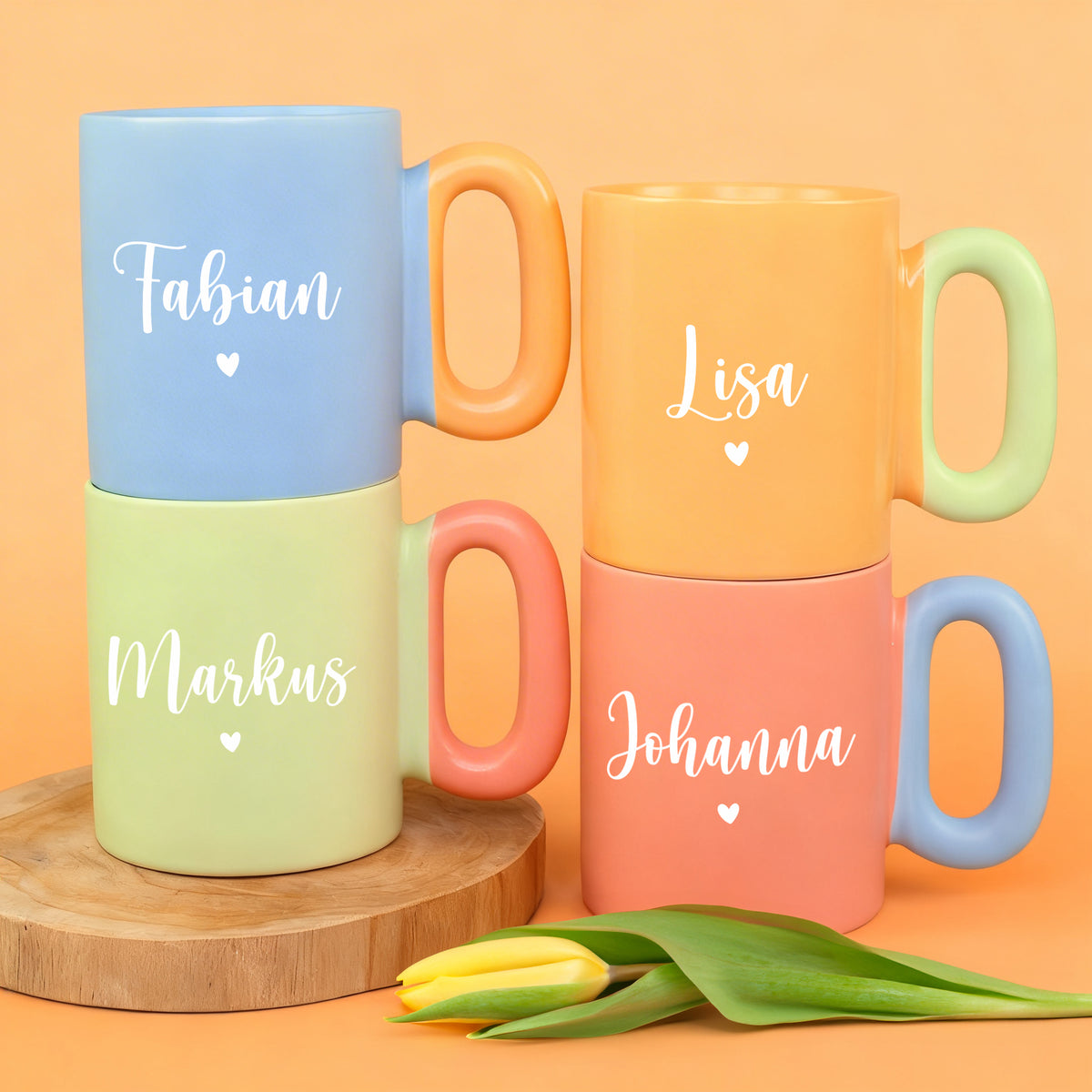 Vier personalisierte Tassen mit Namen und Herzmotiv in Blau, Grün, Orange und Koralle