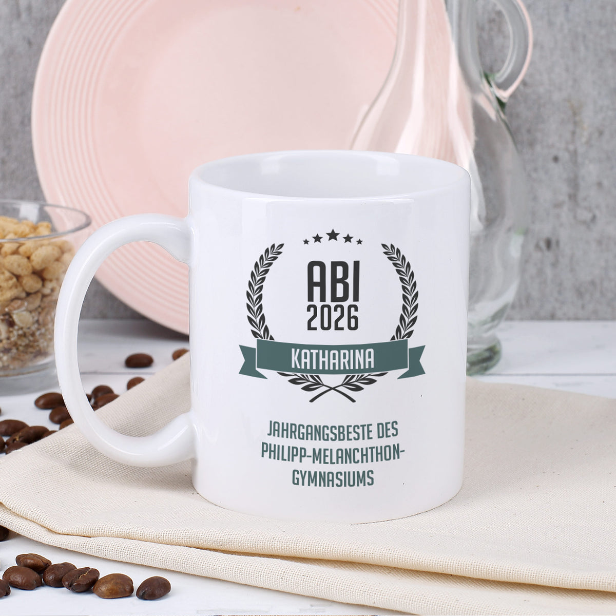 Glückwunsch-Tasse zum Abitur mit Name und Wunschtext dekoriert auf Serviette