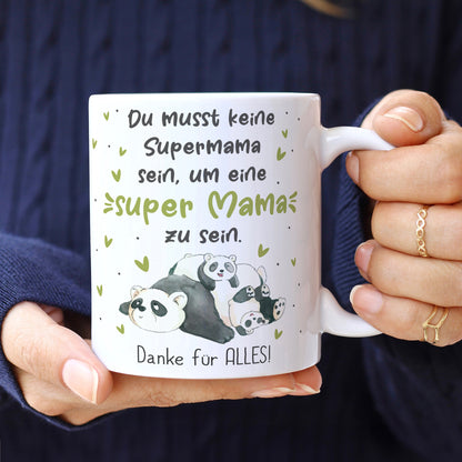 Tasse mit Panda Motiv wird in der Hand gehalten mit Wunschtext für Mama