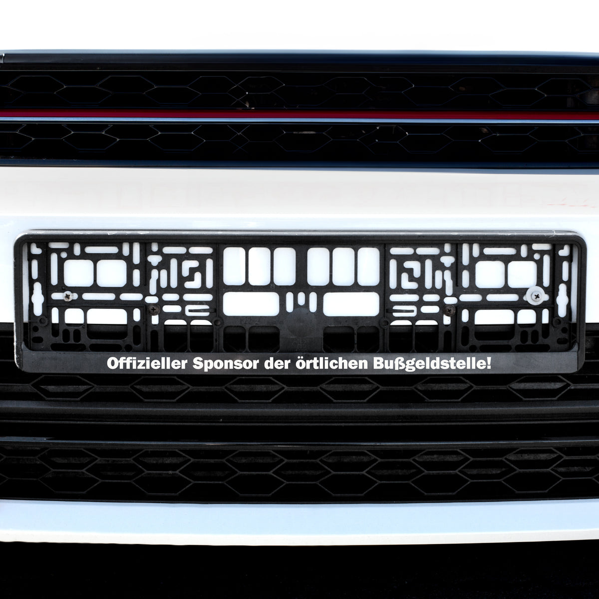 Personalisierter Nummernschildhalter am Auto mit Spruch „Offizieller Sponsor der örtlichen Bußgeldstelle“