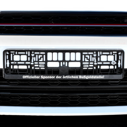 Personalisierter Nummernschildhalter am Auto mit Spruch „Offizieller Sponsor der örtlichen Bußgeldstelle“