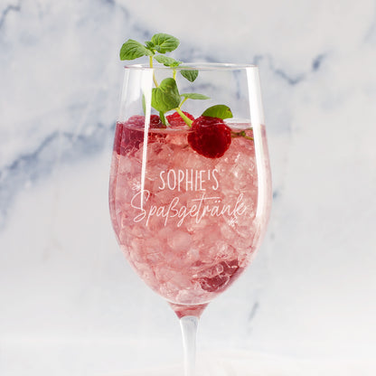 Personalisiertes Weinglas mit Gravur Sophies Spaßgetränk, rosa Drink, Himbeeren und Minze vor hellem Hintergrund