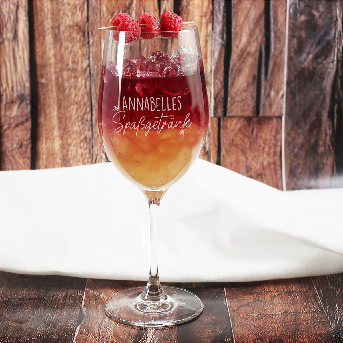 Leonardo Weinglas mit Gravur Annabelles Spaßgetränk, fruchtigem Cocktail und Himbeeren vor Holzhintergrund