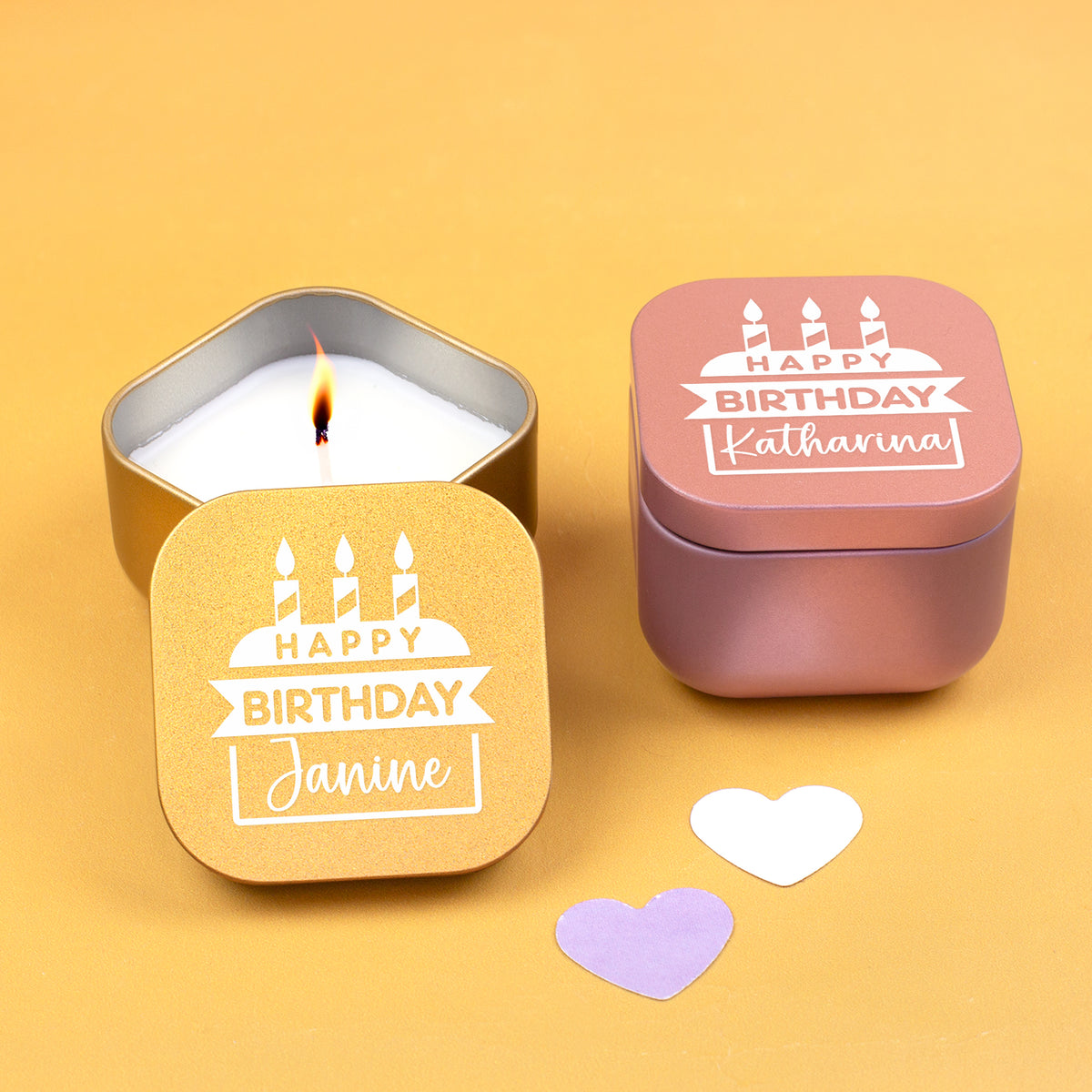 Personalisierte Mini Duftkerzen in Gold und Roségold mit verschiedenen Namen auf gelbem Hintergrund