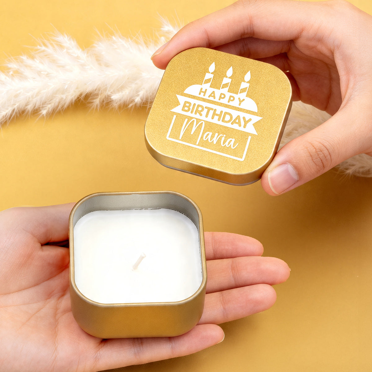 Hände öffnen goldene Mini Duftkerze mit Happy Birthday Motiv und Name Maria