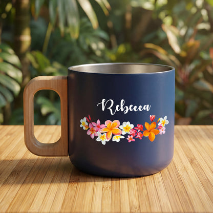 Personalisierter dunkelblauer Edelstahlbecher mit Holzgriff, Blumen-Motiv und Name Rebecca auf Holztisch