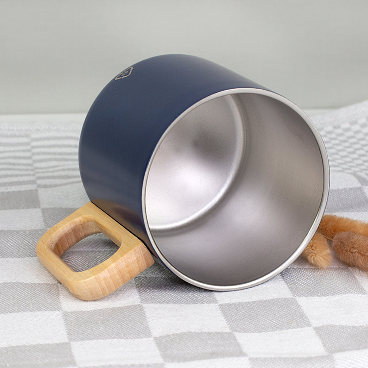 Detailansicht der Edelstahl-Tasse mit silberfarbenem Innenbereich und natürlichem Holzgriff