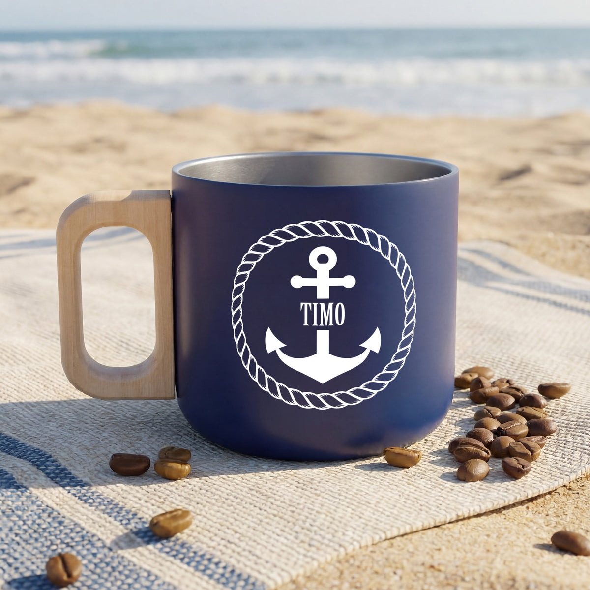 Personalisierter Edelstahlbecher mit Anker-Motiv und Name Timo am Strand mit Kaffeebohnen