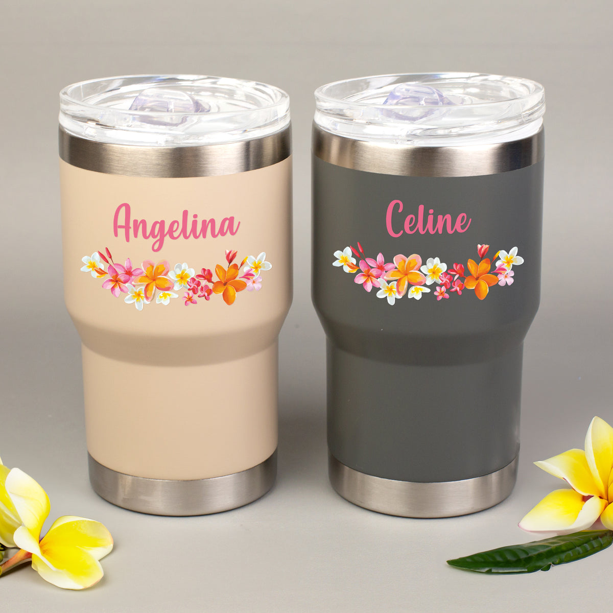 Personalisierter Thermobecher in Beige und Grau mit Blumenmotiv und individuellem Namensaufdruck nebeneinander dargestellt