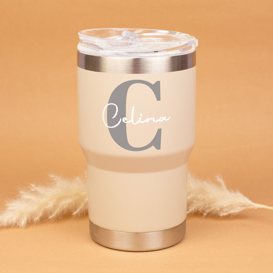 Beigefarbener personalisierter Thermobecher mit großer Initiale C und Name Celina vor warmem Hintergrund