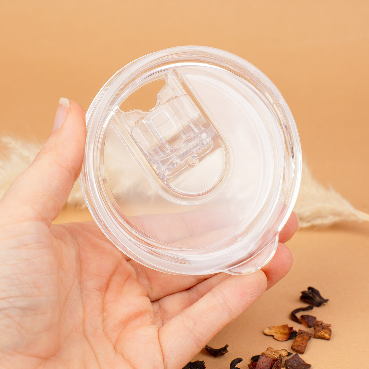 Transparenter Deckel des Thermobechers mit Trinköffnung in einer Hand gehalten